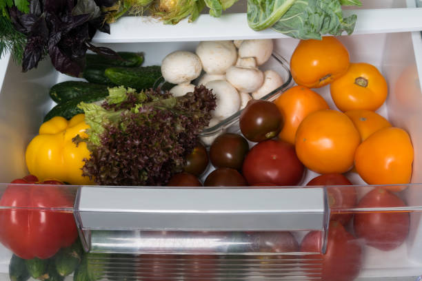 istock mushrooms, herbs and vegetables on a shelf in the refrigerator, front view 1182582916