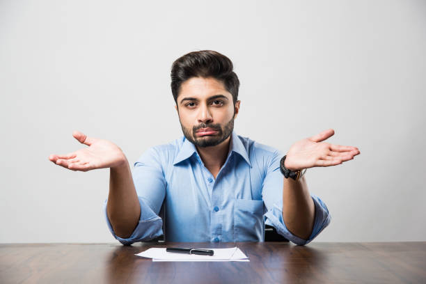 istock Stressed Indian Businessman having headache or Migraine pain while working at office table 1182584408