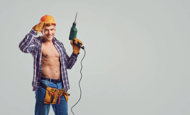 istock Macho male repairman with a drill in his hand 1182585334