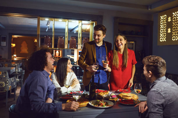 istock Friends at a party in a restaurant talking at the table 1182585403