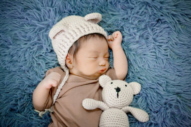 istock Newborn baby sleeping on a blanket grey 1182585424