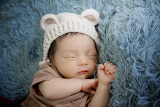 istock Newborn baby sleeping on a blanket grey 1182586486