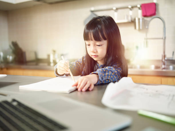 istock little asian girl drawing in kitchen 1182588019