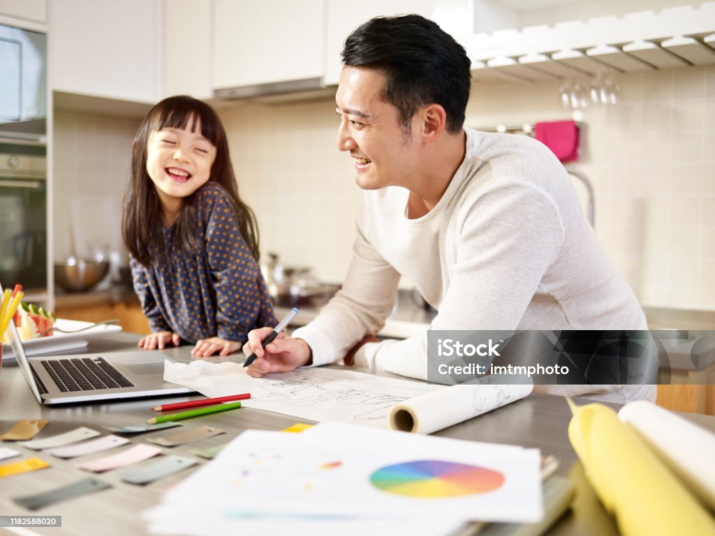 asian father working from home while caring for daughter young asian designer father working at home while taking care of daughter. Daughter Stock Photo