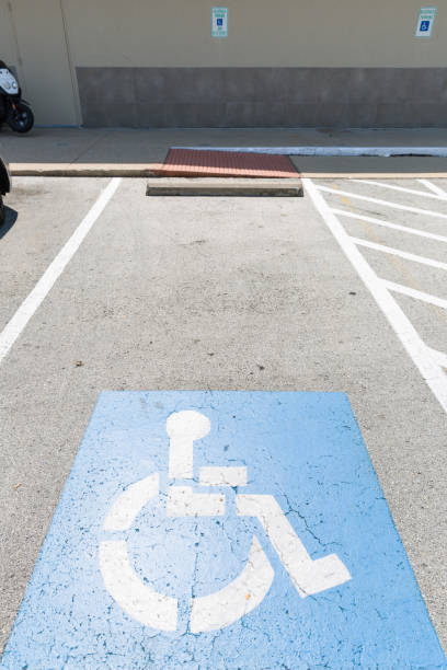 vue du haut sur le panneau de stationnement pour les personnes inables. espace de stationnement pour personnes handicapées et symboles de fauteuil roulant sur asphalte. - slot patinoire de hockey sur glace photos et images de collection