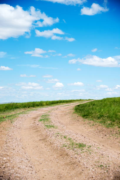 istock Dirt road and blue sky 1182591700