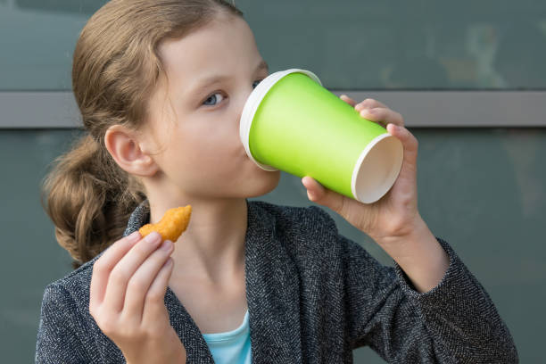 istock girl drinks tea and eats fast food in a restaurant 1182591821