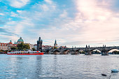 Sightseeing ships  in Vltava river and Charles Bridge in sunset in Prague in Czech Republic