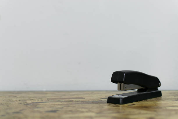 A white stapler is on the table. Stationery.