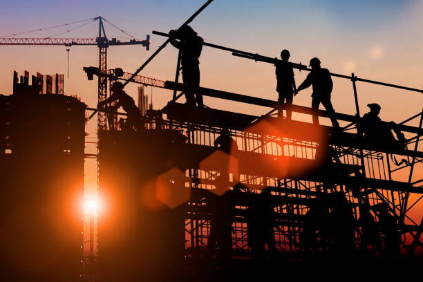 istock Silhouette Two engineers consult and inspect high-rise construction work over blurred industry background with Light fair.Create from multiple reference images together 1182593750