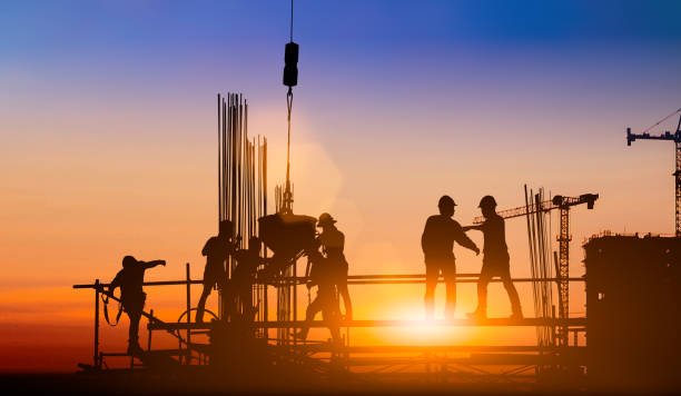 istock Silhouette of engineer and construction team working at site over blurred background for industry background with Light fair.Create from multiple reference images together 1182593753