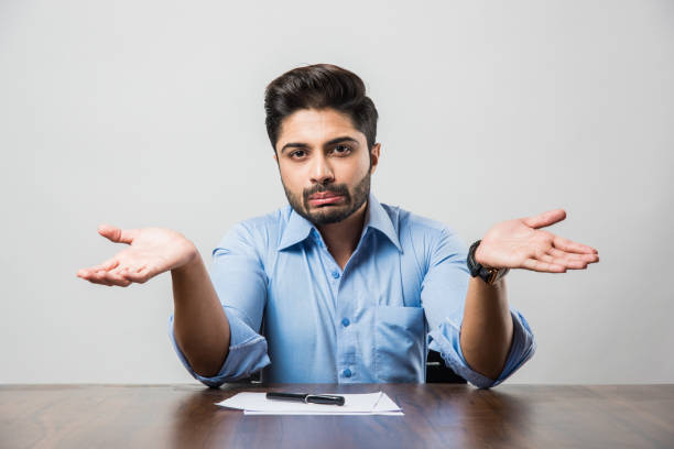 istock Stressed Indian Businessman having headache or Migraine pain while working at office table 1182593983