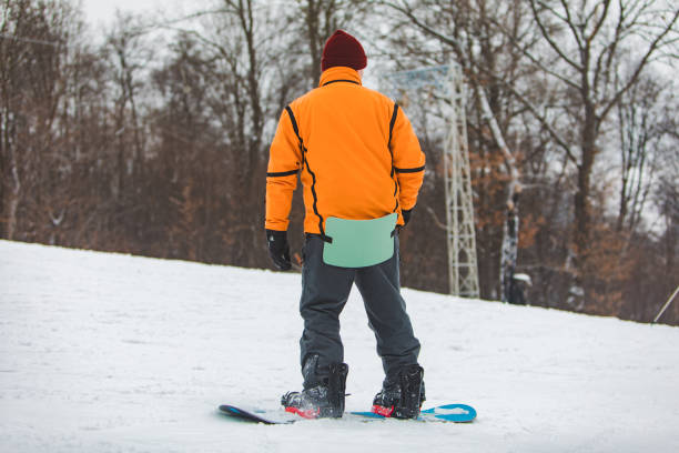 istock man snowboarding down by hill. winter sport time 1182594281