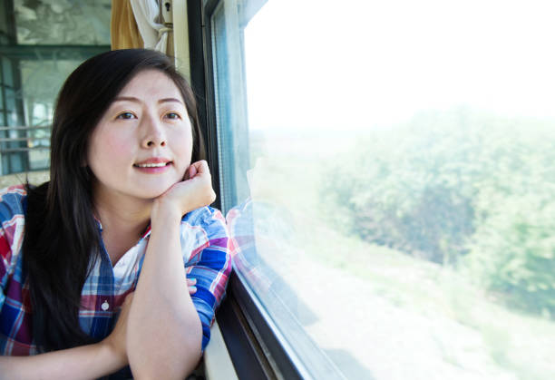 istock Beautiful woman looking out the train window 1182595383