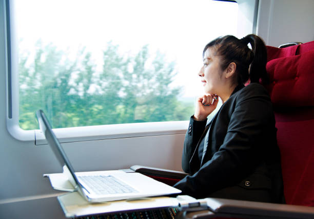 istock Young businesswoman using a laptop on the train 1182596401