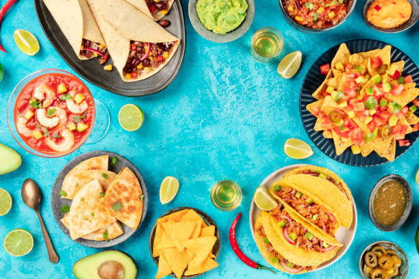 メキシコ料理、メキシコ料理の多くの料理、平らなレイ、鮮やかな青い背景の上から撮影し、テキストのための場所を持つフレームを形成 - drink mexican culture tequila shot tequila ストックフォトと画像