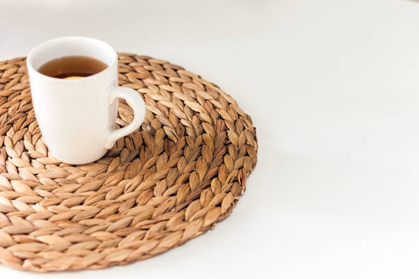 istock lemon tea in a white ceramic cup on a straw wicker stand on the table 1182597885