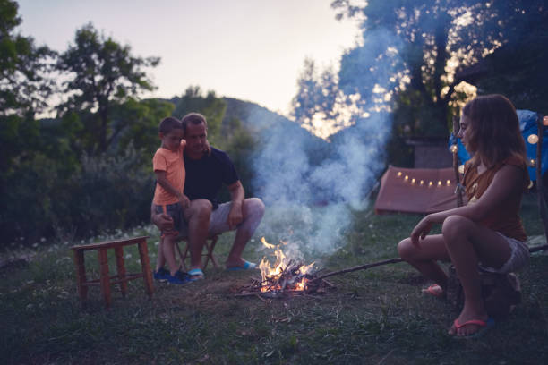 istock Father with children making a camping fire in the backyard. 1182598994