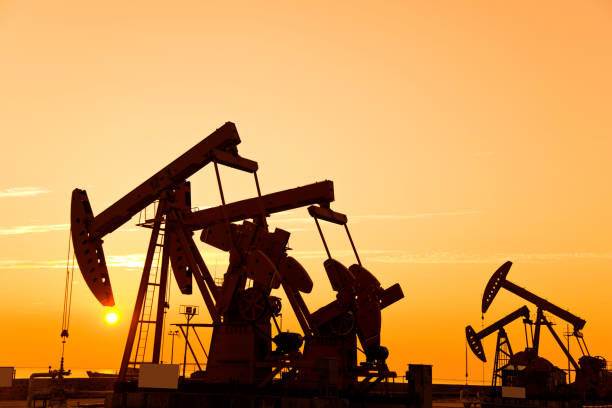 istock Oil pumps and rig at sunset 1182600585