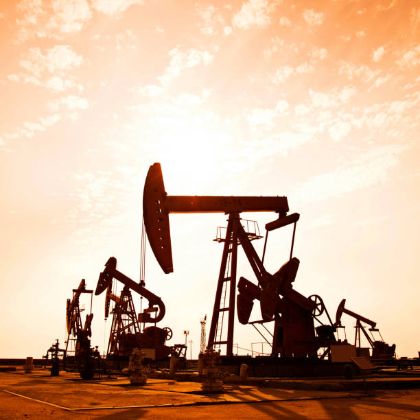 istock Oil pumps and rig at sunset 1182600591