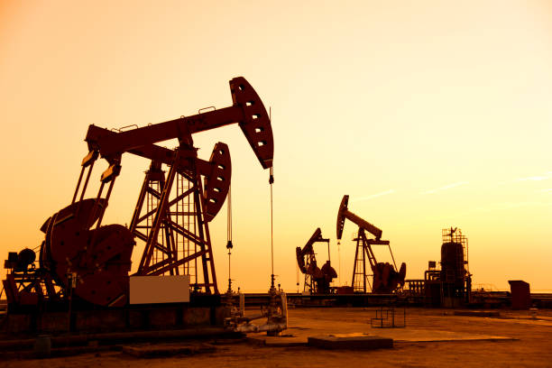 istock Oil pumps and rig at sunset 1182600616