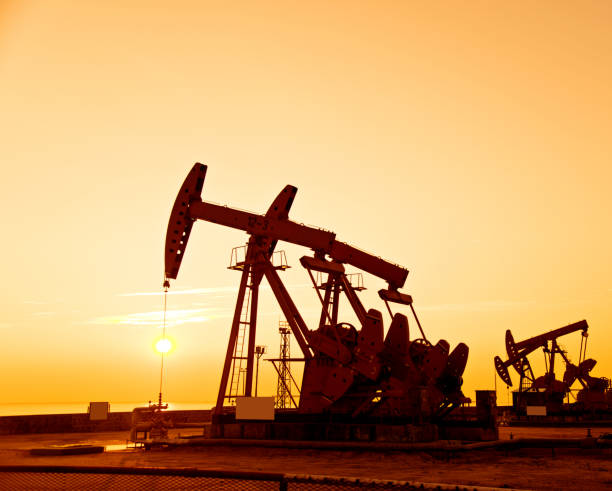 istock Oil pumps and rig at sunset 1182600722