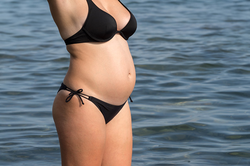 Pregnant woman enjoying the sea at sunny day