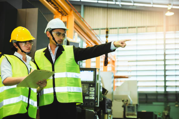 istock Asian engineer factory inspection with man business engineer hold computer and Pointing finger in industry we wears a helmet female working metalwork control in industrial In a plastic factory for car 1182601071
