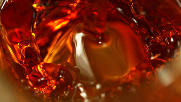 super macro colpo di spirito versato nel vetro - whisky alcohol pouring glass foto e immagini stock