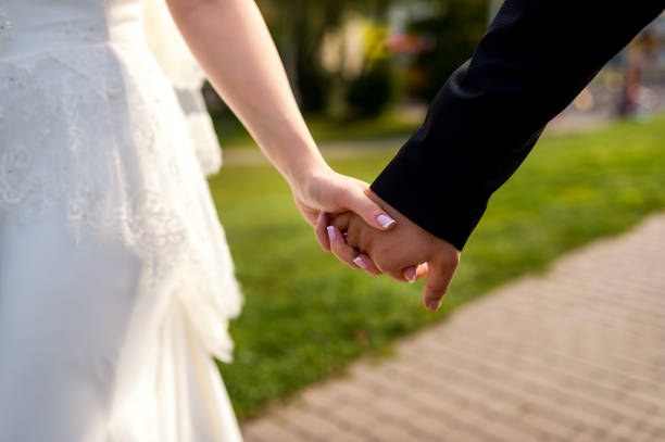 istock Wedding theme, holding hands newlyweds. 1182606117