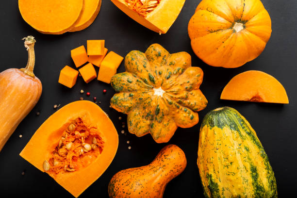 istock Different types of pumpkins on a black background. Top view. 1182609210