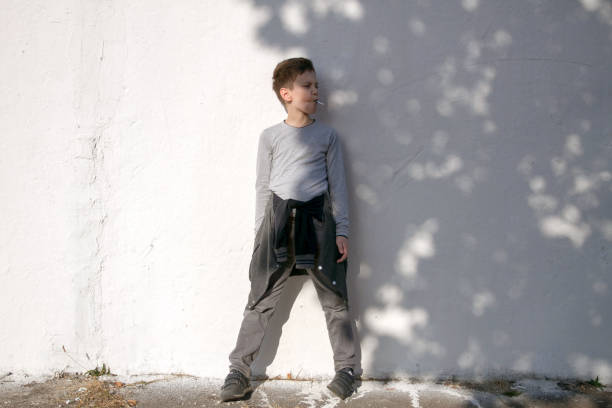 istock Cute serious boy against white wall. Boy with blue lollipop 1182609797