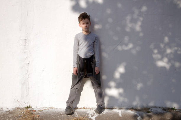 istock Cute serious boy against white wall. Boy with blue lollipop 1182609819