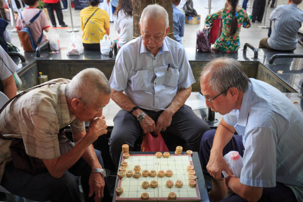 le vieil homme chinois jouent aux échecs dans la place ouverte de ville de chine de singapour - chinese chess leisure games chinese culture traditional culture photos et images de collection