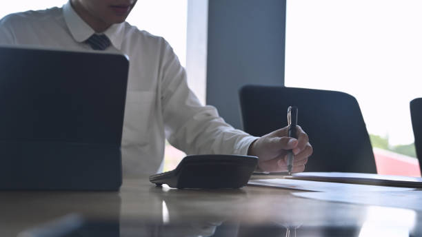 istock Close-up young businessman writing on paper and analysis data. 1182610254
