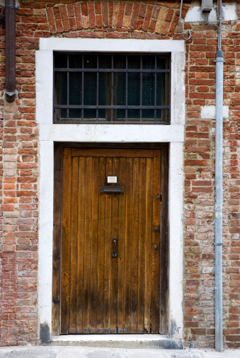 Ancient wooden door with hinges and knocker wrought iron handicraft