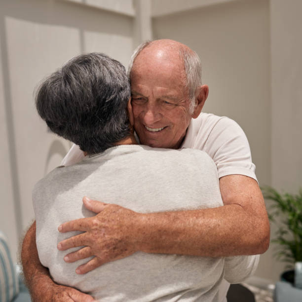 istock Smiling senior man affectionately hugging his wife at home 1182613194