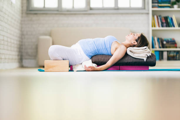 istock Pregnant woman practicing yoga at home -  reclining bound angle pose (supta baddha konasana) 1182613330