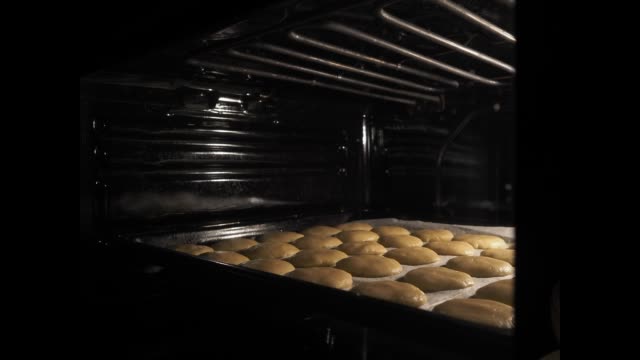 Baking homemade cookies in the oven. Shortbread cookies increase in size during the baking process.