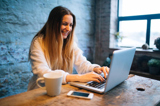 istock Beautiful woman using laptop at home 1182615039