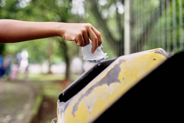 istock Close up children hand throwing plastic trash into the recycling trash bin 1182615086