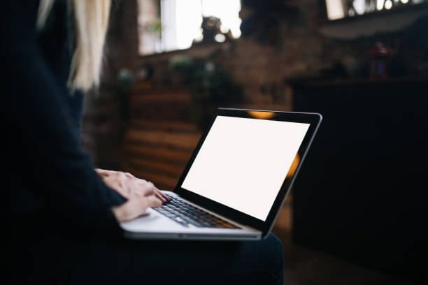 Young woman using laptop with blank screen