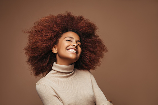 Photo of cheerful curly girl with positive emotions