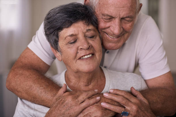 istock Affectionate senior couple hugging while sitting in a retirement home 1182617684
