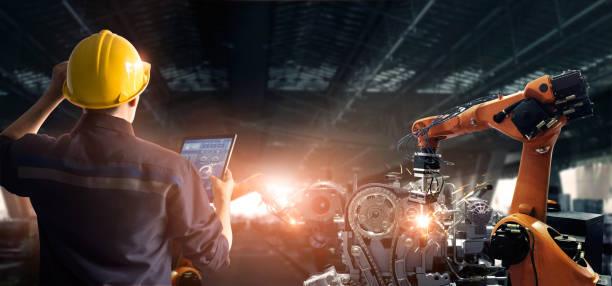 istock Engineer check and control welding robotics automatic arms machine in intelligent factory automotive industrial with monitoring system software. Digital manufacturing operation. Industry 4.0 1182619242