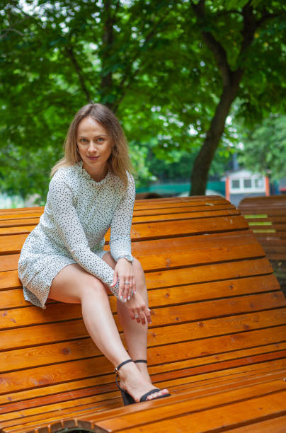 istock Young beautiful model posing on wooden bench 1182622561
