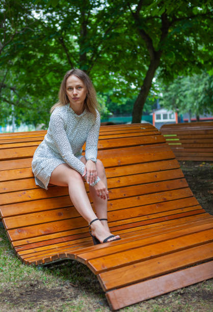 istock Young beautiful model posing on wooden bench 1182622588