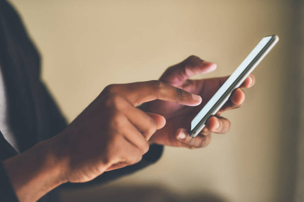 Connecting has never been easier Cropped shot of an unrecognizable man using a smartphone while sitting indoors never stock pictures, royalty-free photos & images