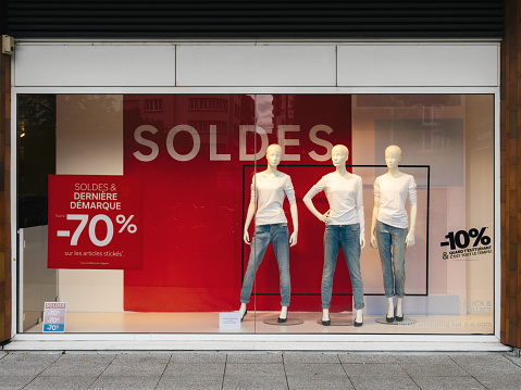 Paris, France - Jul 27, 2017: Soldes inscription with mannequins wearing elegant clothes and special last minutes 70 percent discount sales for fashion products on central Avenue