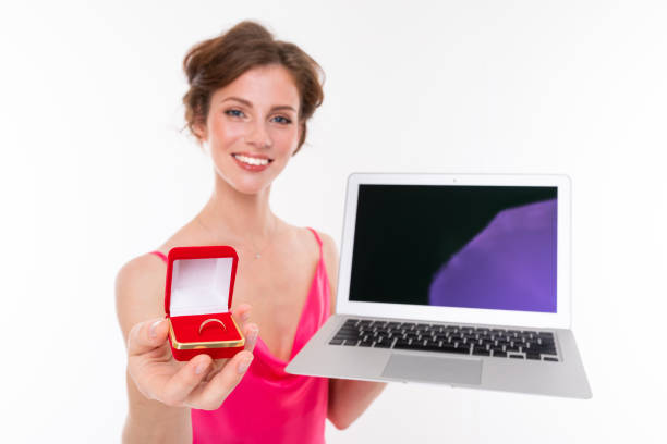 bride's half-length shot with engagement ring and laptop